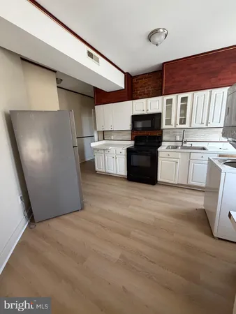 a kitchen with granite countertop a refrigerator stove top oven and sink