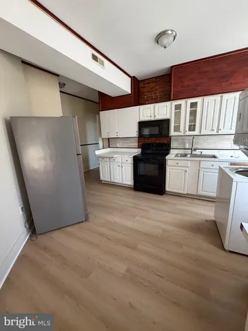 a kitchen with granite countertop a refrigerator stove top oven and sink