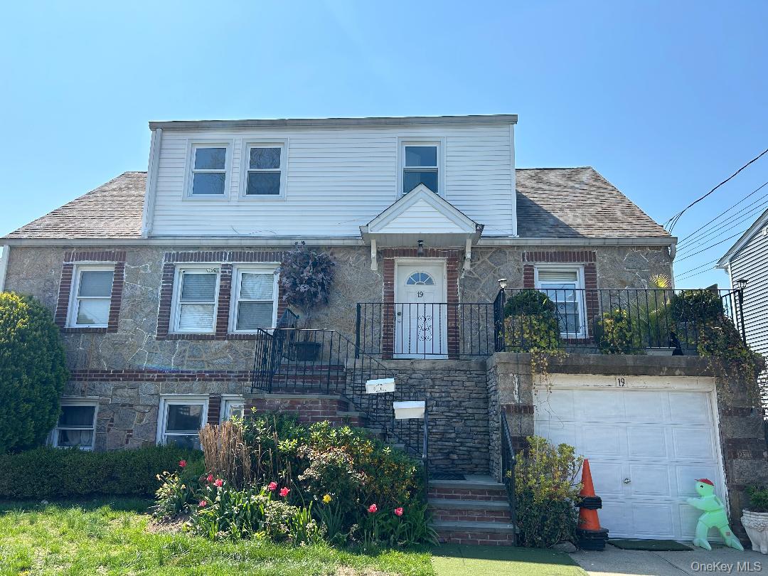 19 Firwood Road, Unit 2 Port Washington, NY 11050 - Photo 1 of 9 View of front facade featuring stone siding, a shingled roof, and a garage