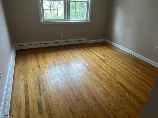 a view of a room with wooden floor and a window