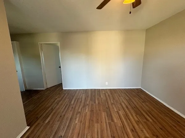 an empty room with wooden floor and closet