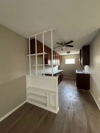 a view of a living room with wooden floor and windows