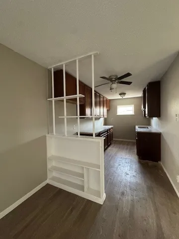a view of a living room with wooden floor and windows