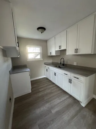 a kitchen with granite countertop white cabinets and white appliances
