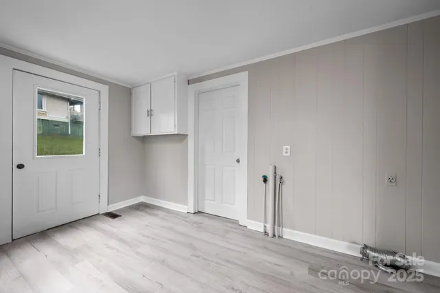 a view of an empty room with wooden floor and entryway
