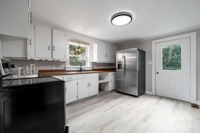 a kitchen with stainless steel appliances granite countertop a refrigerator a sink dishwasher a stove with wooden cabinets and floor