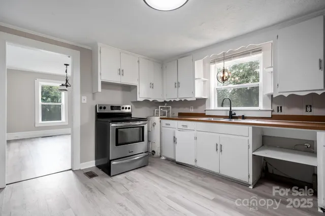 a kitchen with granite countertop white cabinets and white appliances