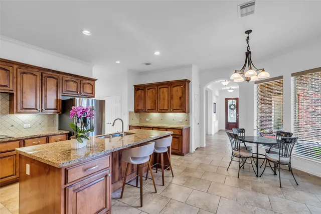 a kitchen with a dining table chairs sink and granite counter tops