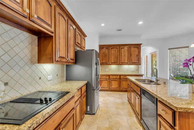 a kitchen with stainless steel appliances granite countertop a sink stove and refrigerator