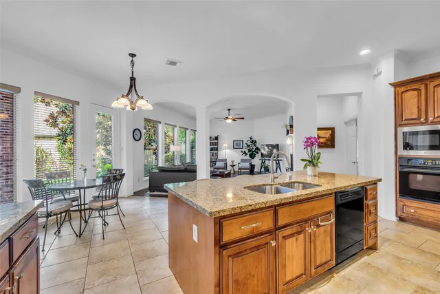 a kitchen with stainless steel appliances granite countertop a sink and a refrigerator