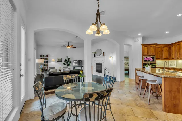 a view of a dining room and a kitchen with a table chairs