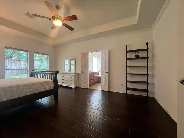 a view of a bedroom with wooden floor and windows