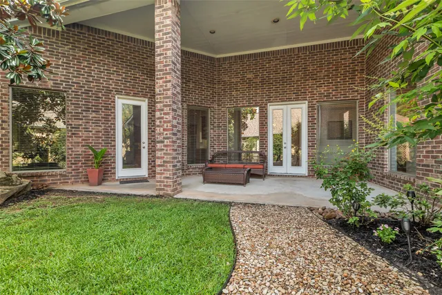 a view of a brick house with a large windows and plants