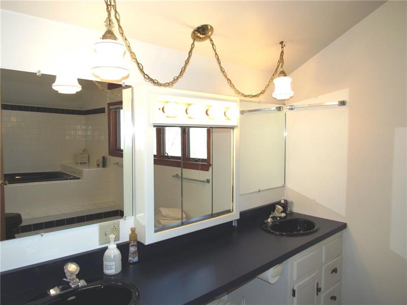 354 Lake Road Somerset, PA 15502 - Photo 15 of 25 In between the two sinks there's a seat for the vanity mirror. You can see the jetted tub in the mirrors reflection.