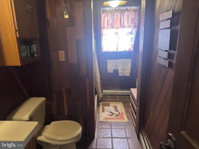a white toilet sitting next to a bathroom sink and a mirror