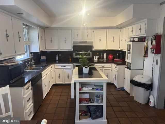 a kitchen with stainless steel appliances a stove a sink and a refrigerator
