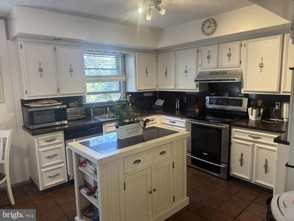 a kitchen with cabinets appliances and a window