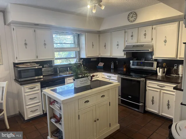 a kitchen with cabinets appliances and a window