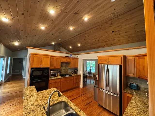 a kitchen with stainless steel appliances granite countertop a refrigerator and a stove