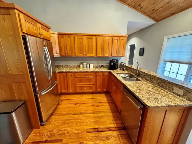 a kitchen with stainless steel appliances granite countertop a refrigerator stove and sink