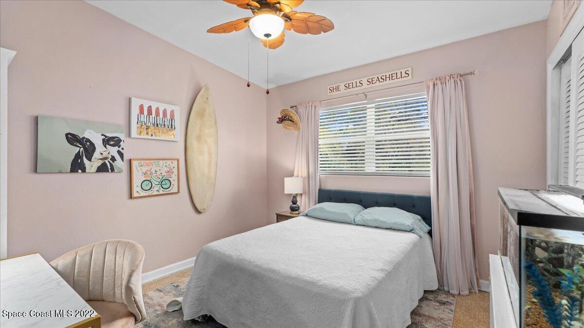 912 Bali Road Cocoa Beach, FL 32931 - Photo 23 of 48 a bedroom with a bed and a chandelier