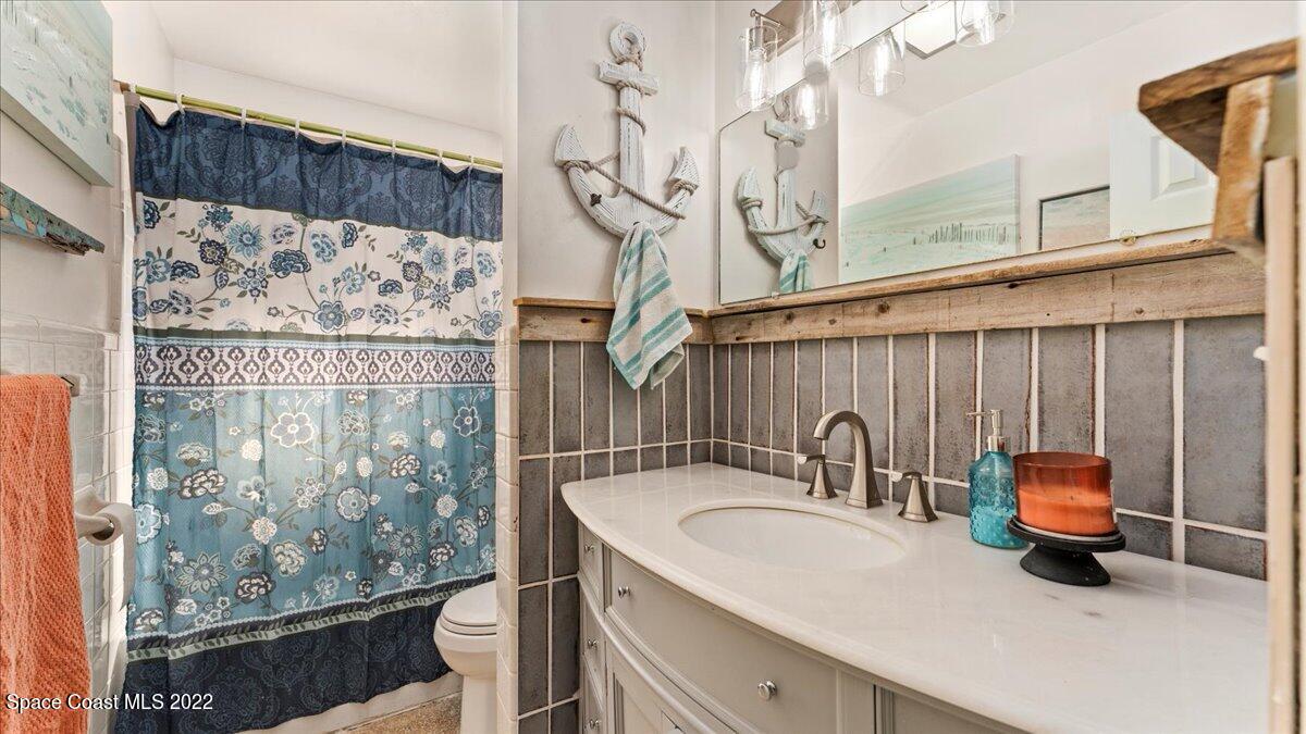 912 Bali Road Cocoa Beach, FL 32931 - Photo 27 of 48 a bathroom with a sink a toilet and shower