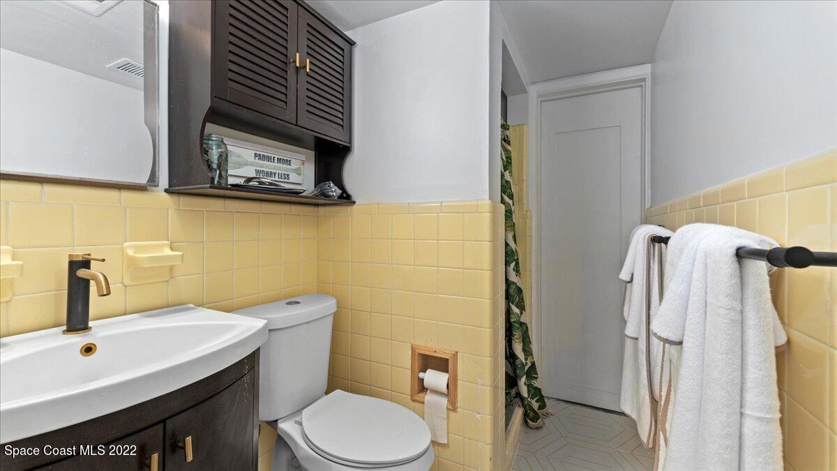 912 Bali Road Cocoa Beach, FL 32931 - Photo 31 of 48 a bathroom with a toilet sink and mirror