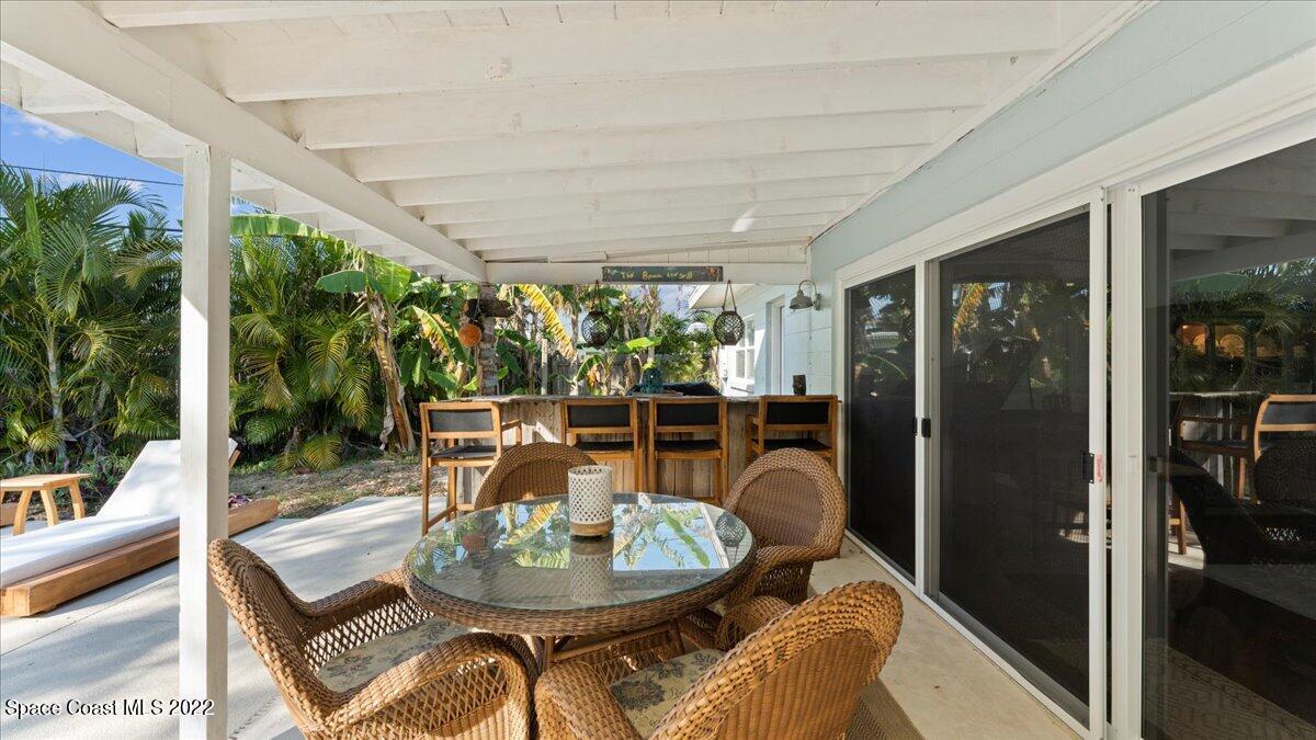 912 Bali Road Cocoa Beach, FL 32931 - Photo 36 of 48 a dining room with furniture and a floor to ceiling window