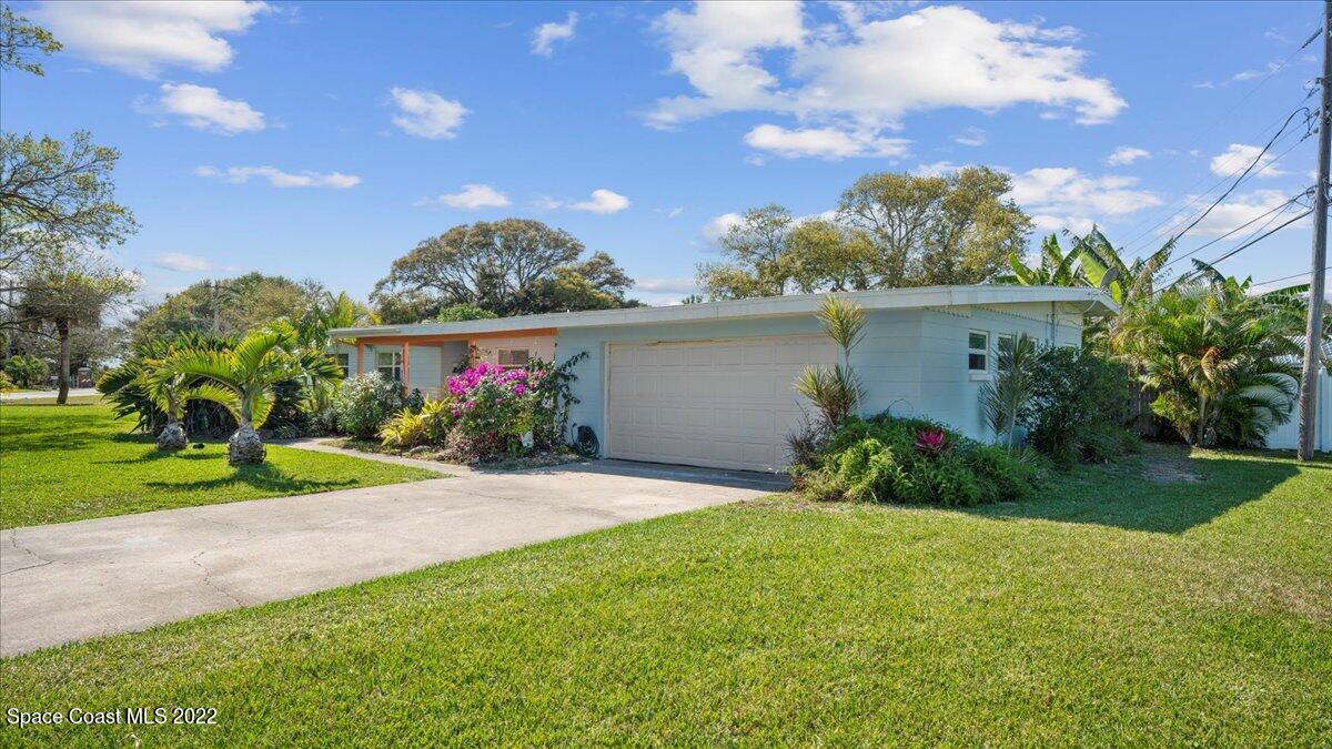 912 Bali Road Cocoa Beach, FL 32931 - Photo 7 of 48 a view of a house with a yard and a garden