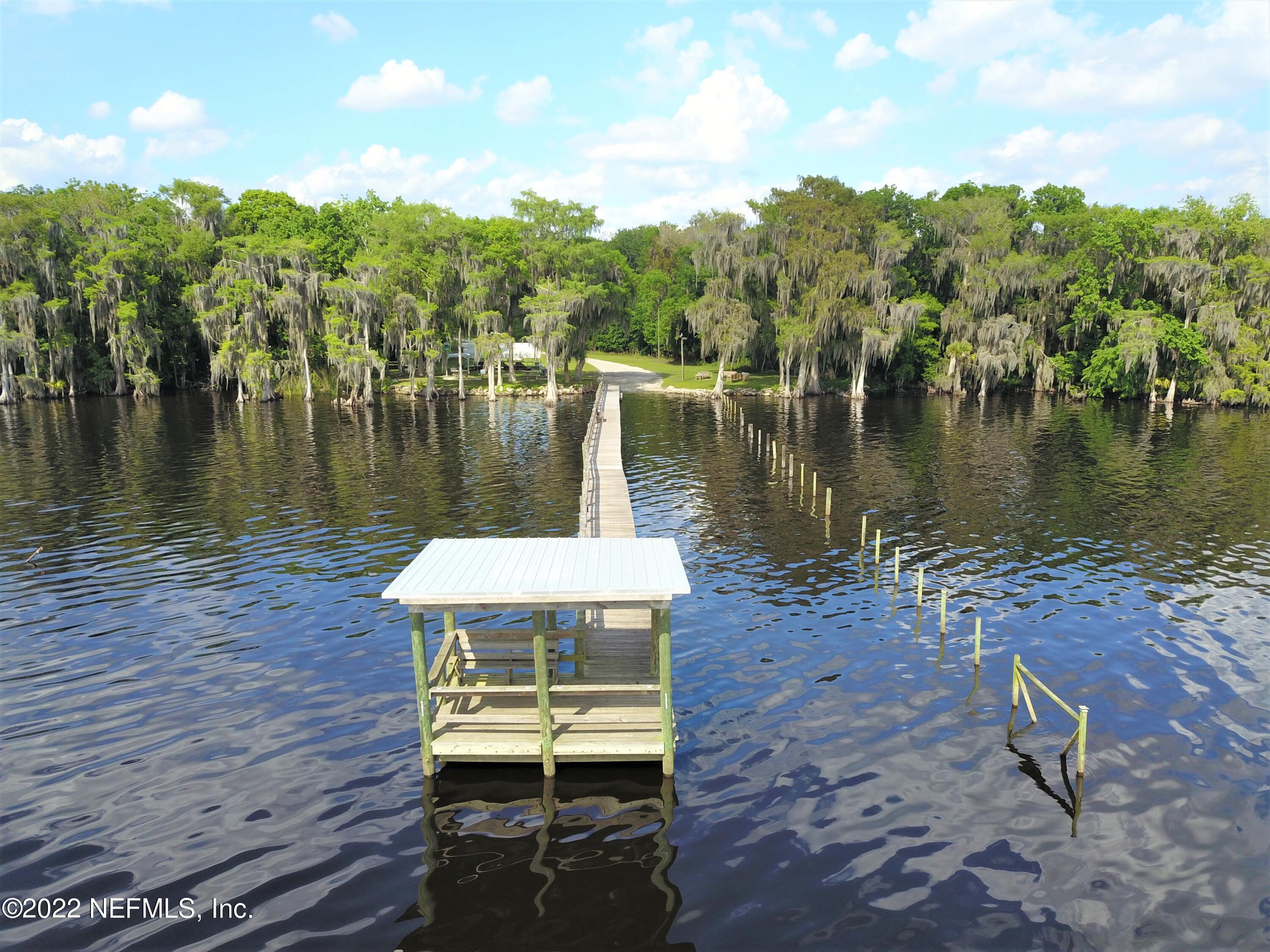 113 3rd Street Georgetown, FL 32139 - Photo 4 of 13 a wooden bench sitting next to a lake