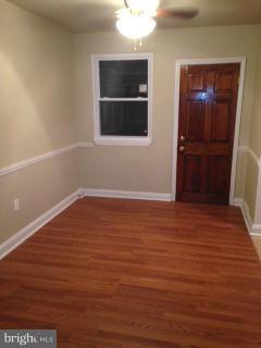 6966 Reisterstown Road Baltimore, MD 21215 - Photo 4 of 17 a view of an empty room with wooden floor and a window