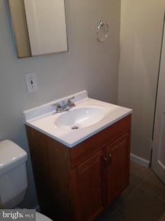 6966 Reisterstown Road Baltimore, MD 21215 - Photo 6 of 17 a utility room with a sink a vanity and mirror