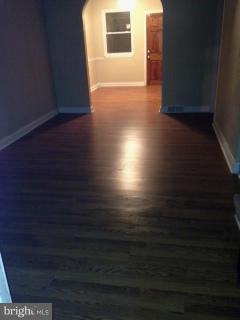 6966 Reisterstown Road Baltimore, MD 21215 - Photo 8 of 17 a view of an empty room with wooden floor and a window