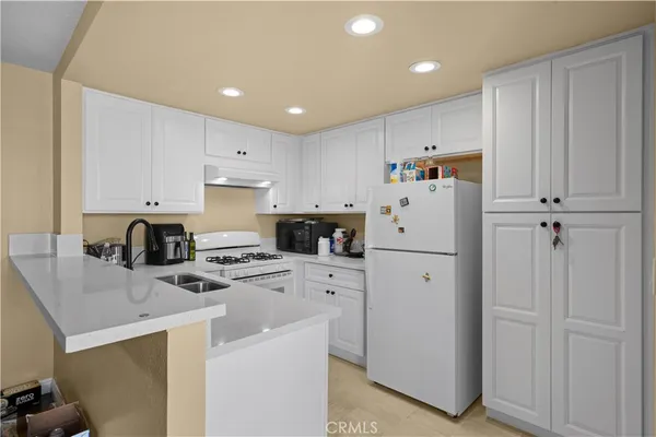 a kitchen with white cabinets stainless steel appliances and sink