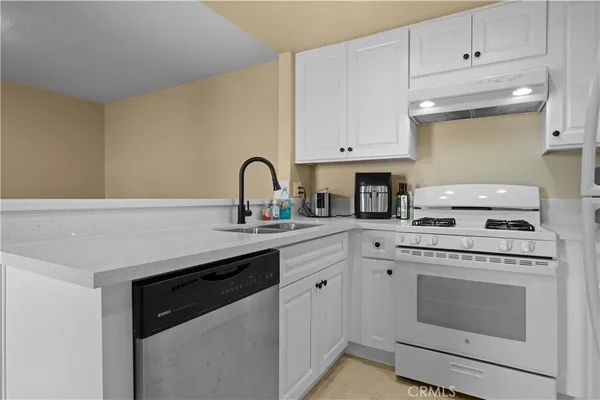 a kitchen with a white stove top oven and white refrigerator