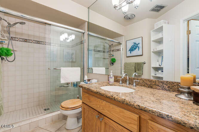 2901 Peninsula Road, Unit 248 Oxnard, CA 93035 - Photo 13 of 26 a bathroom with a granite countertop sink a toilet a mirror and shower