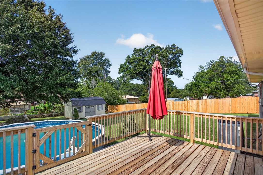 118 Bryson Road Anderson, SC 29625 - Photo 28 of 36 An elevated wooden deck overlooks a fenced backyard with an above-ground pool and storage shed.