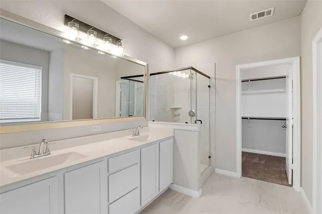 a spacious bathroom with a shower sink and mirror