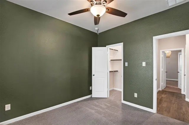 a view of an empty room with a chandelier fan