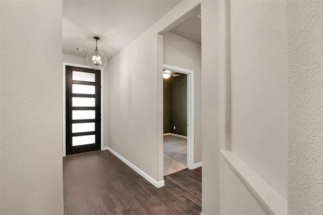 an empty room with wooden floor closet and windows