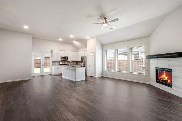 a view of kitchen with livingroom and fireplace with wooden floor
