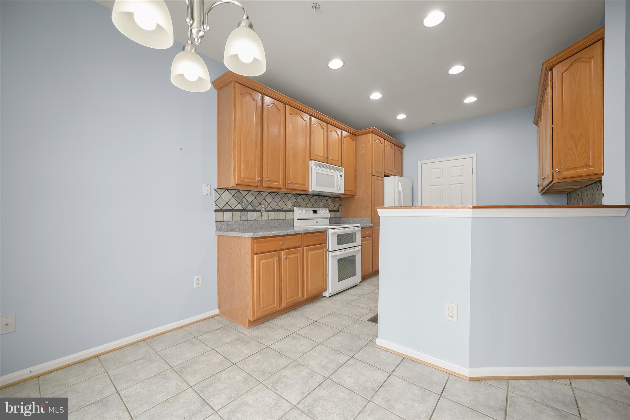 6428 Hickory Overlook, Unit 71 Columbia, MD 21044 - Photo 24 of 63 a kitchen with granite countertop white cabinets and stainless steel appliances