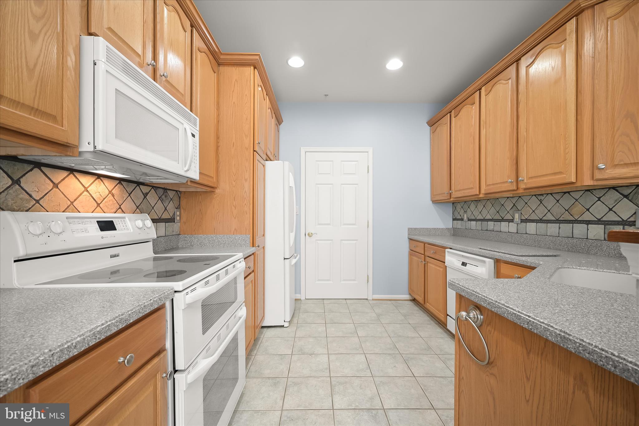 6428 Hickory Overlook, Unit 71 Columbia, MD 21044 - Photo 26 of 63 a kitchen that has a sink a stove and a oven