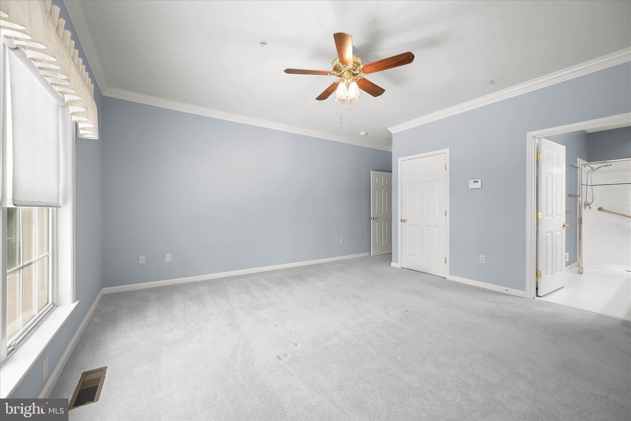 6428 Hickory Overlook, Unit 71 Columbia, MD 21044 - Photo 36 of 63 an empty room with a ceiling fan and windows