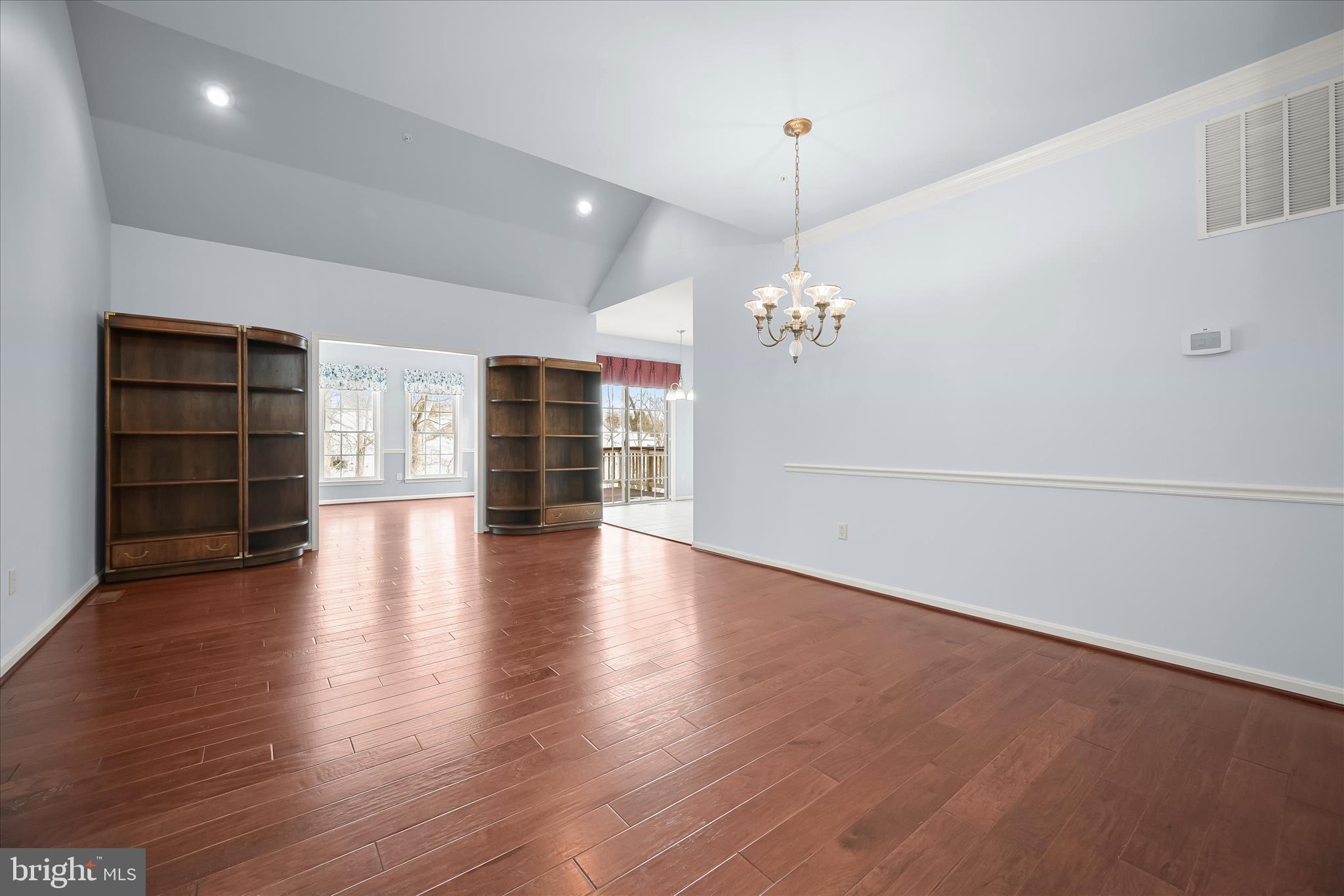 6428 Hickory Overlook, Unit 71 Columbia, MD 21044 - Photo 7 of 63 an empty room with wooden floor chandelier and windows