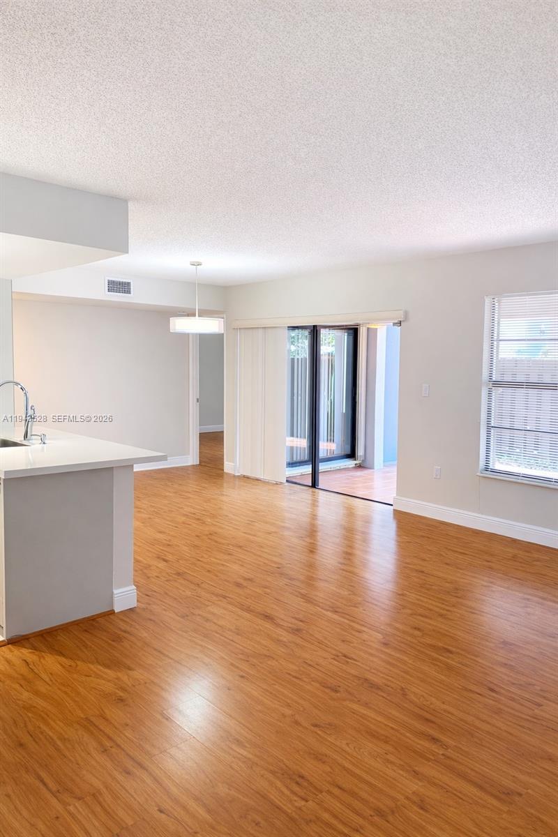9033 Southwest 123rd Court, Unit 105 Miami, FL 33186 - Photo 3 of 11 a view of empty room with wooden floor and fan