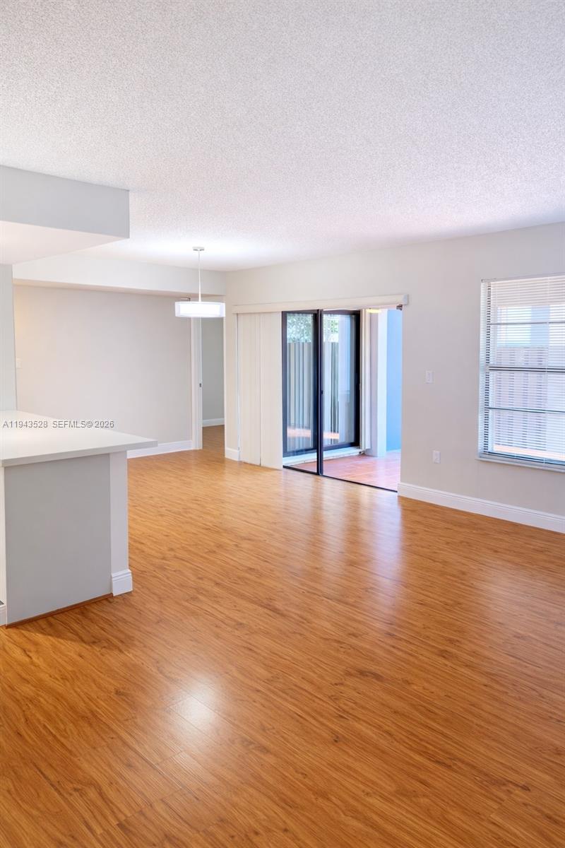 9033 Southwest 123rd Court, Unit 105 Miami, FL 33186 - Photo 4 of 11 a view of an empty room with window and wooden floor