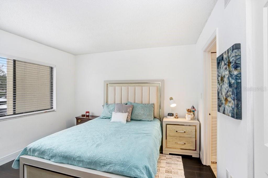 13602 South Village Drive, Unit 1205 Tampa, FL 33618 - Photo 15 of 51 a bedroom with a bed and wooden floor