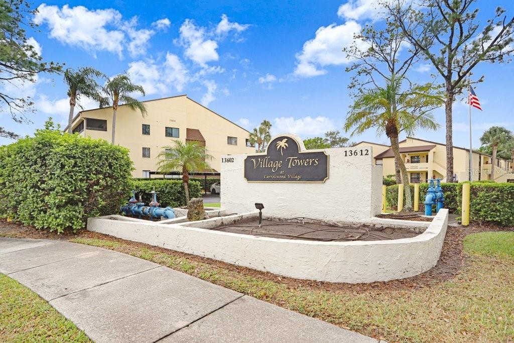 13602 South Village Drive, Unit 1205 Tampa, FL 33618 - Photo 22 of 51 a view of a white house with a yard and potted plants