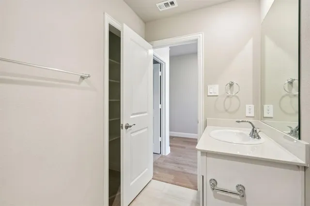 a bathroom with a bathtub shower sink vanity mirror and toilet